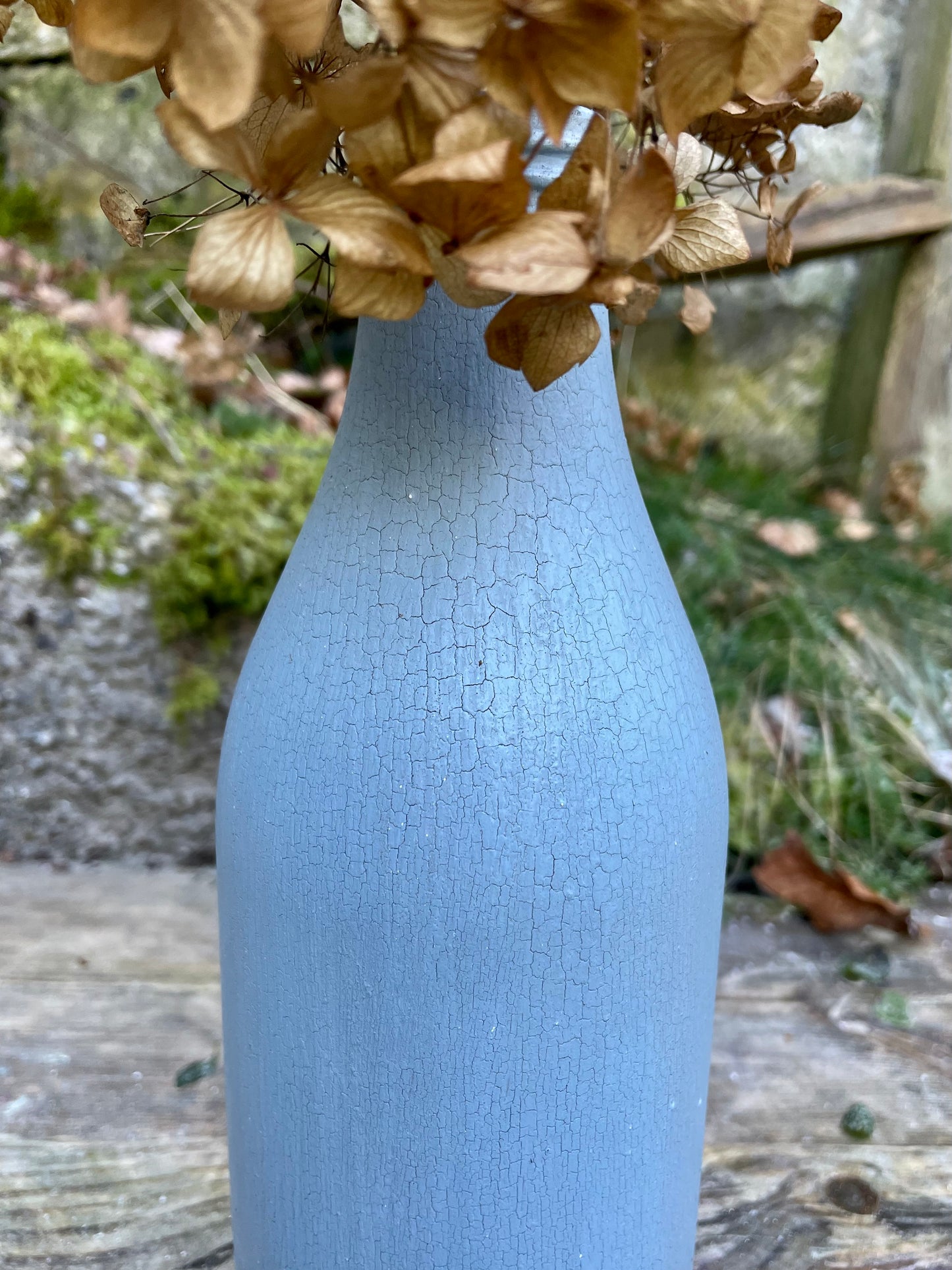 Bottle bud vase painted in layers of textured crackled blue milk paint