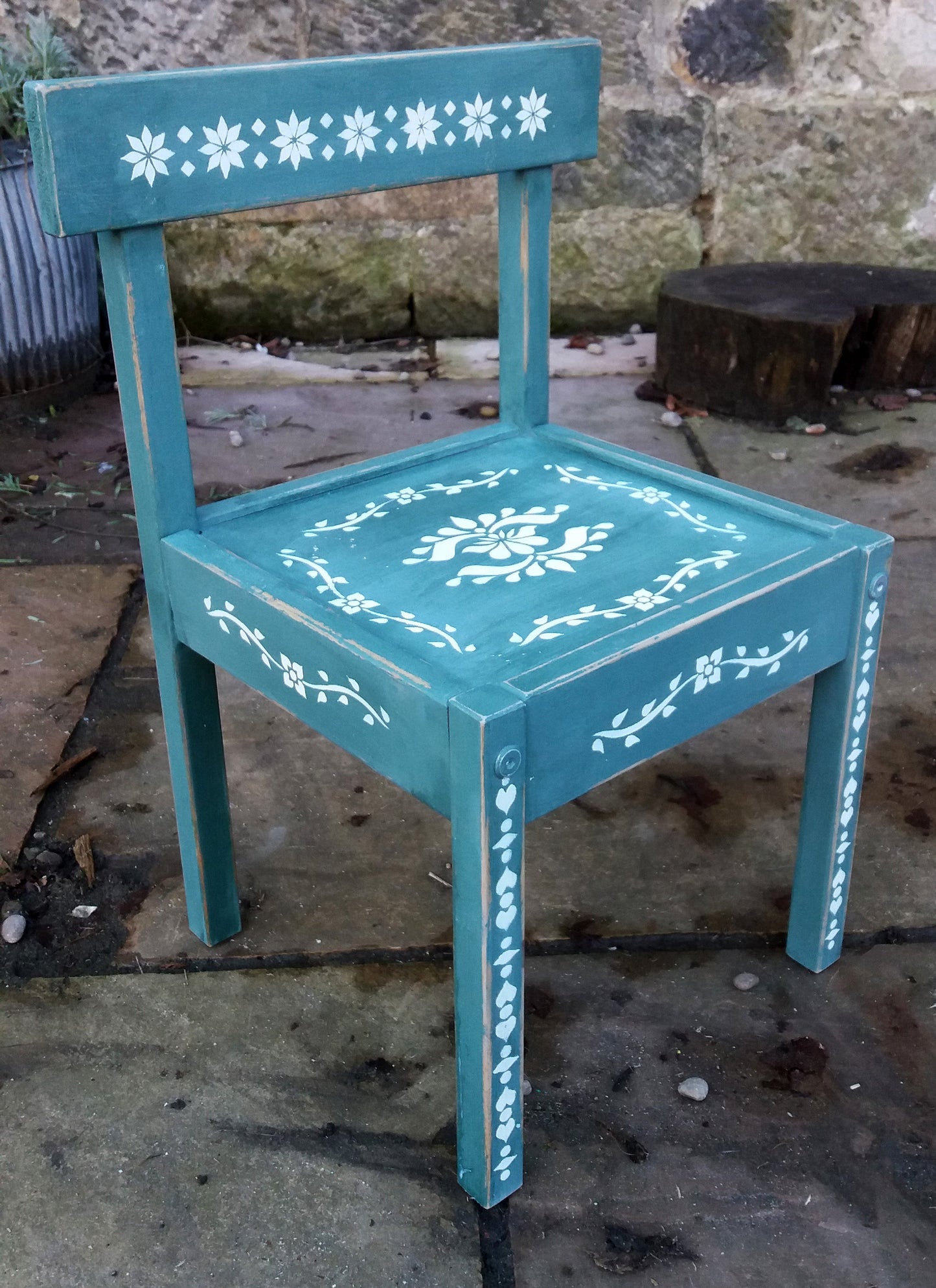 Little Children's chair painted in a deep green with folk art stencil design in white