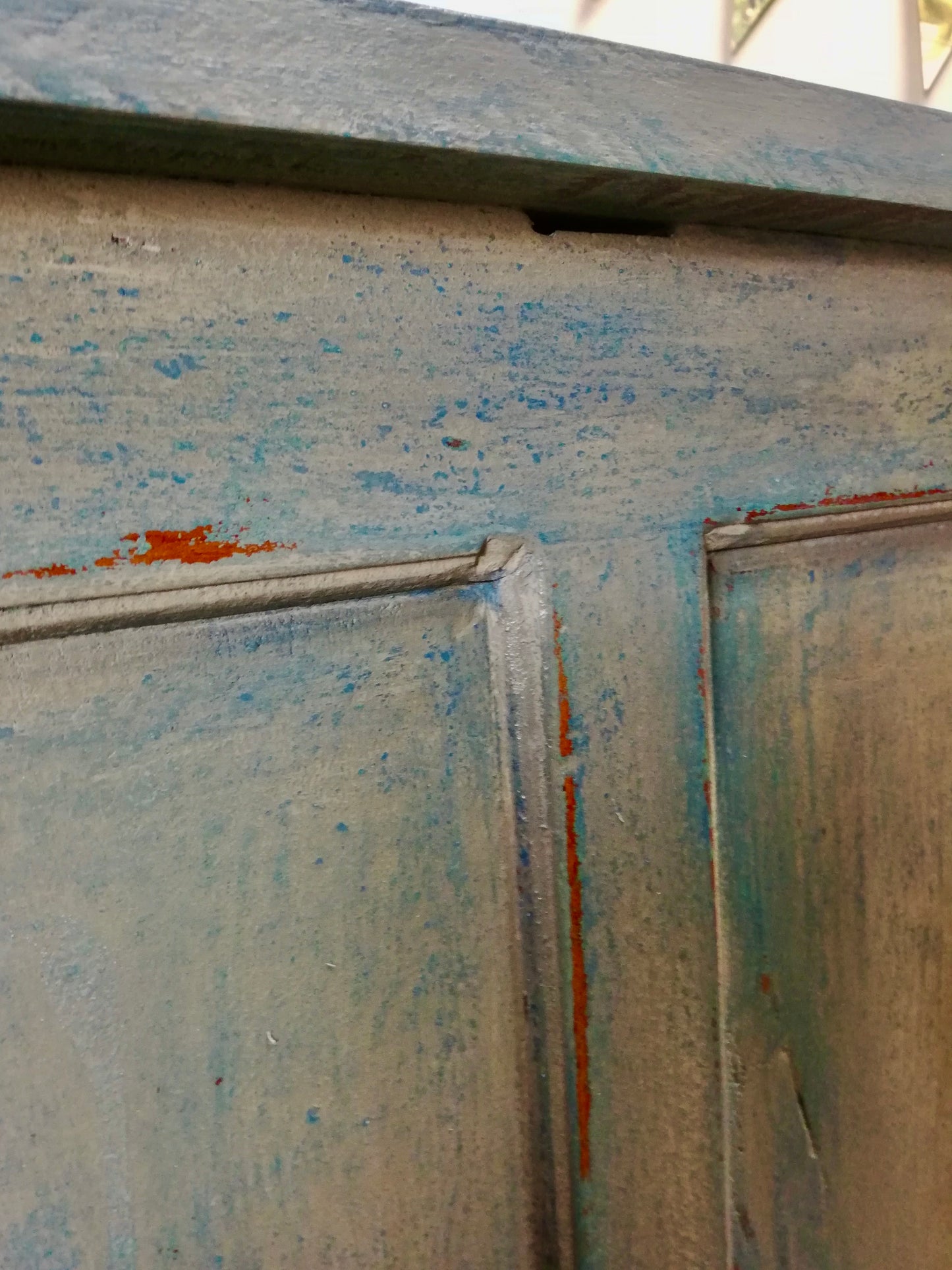Vintage wooden filing cabinet painted in chippy layers of blue and grey.