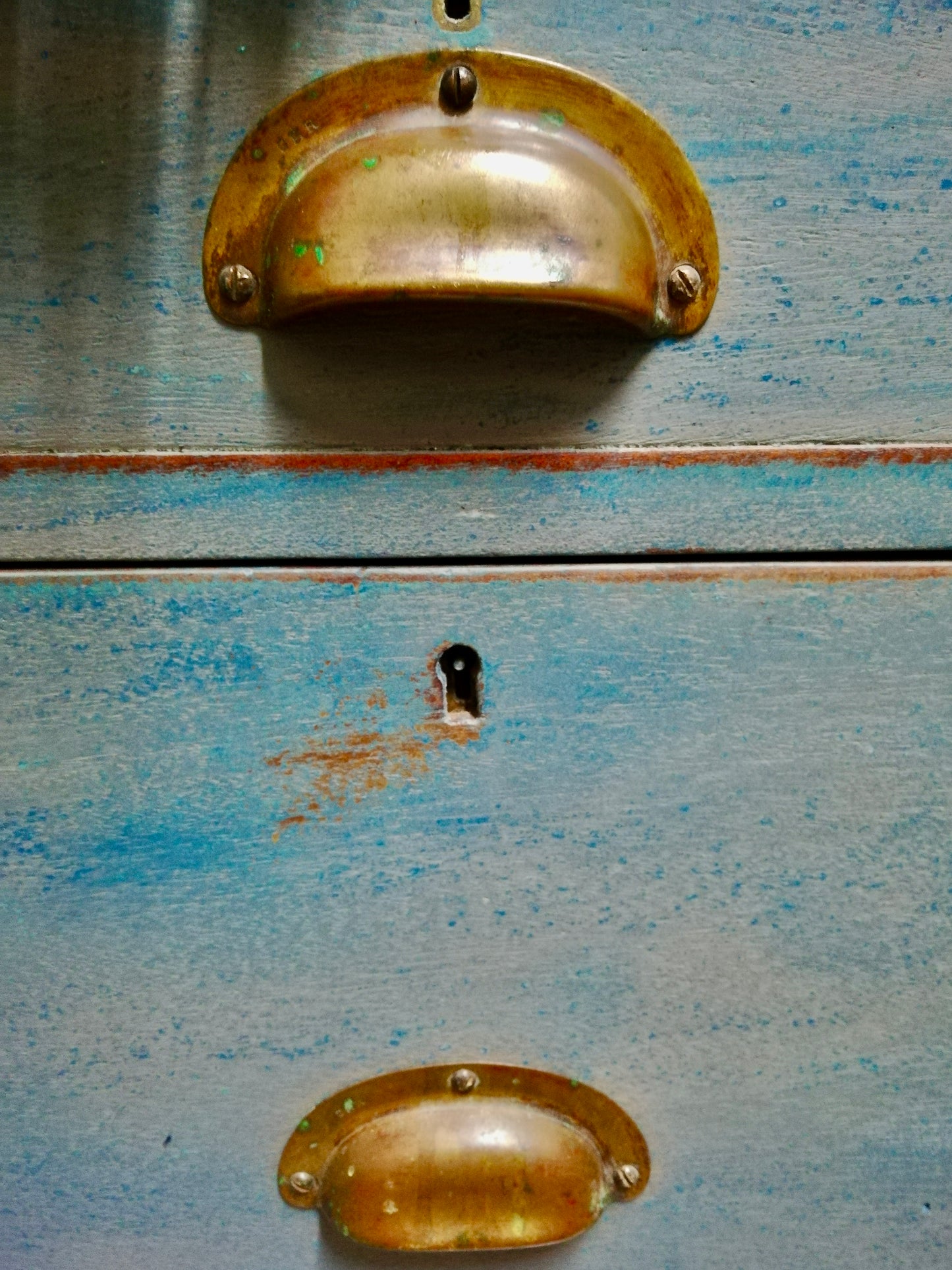 Vintage wooden filing cabinet painted in chippy layers of blue and grey.
