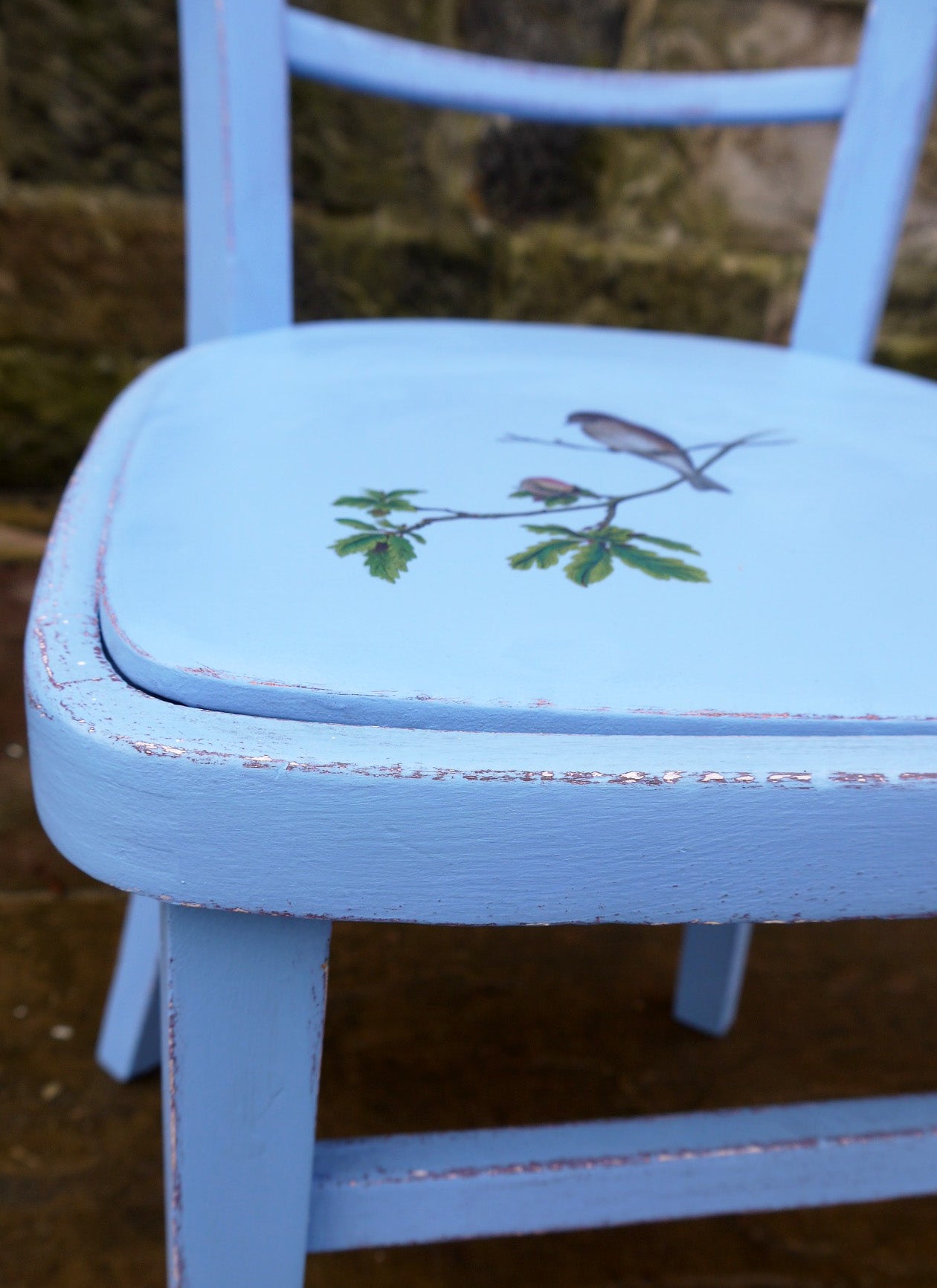 Little painted chair with painted vinyl seat and bird design. The woodwork has been painted in layers of aubergine and bright blue andxa bird on a branch has been added to the old vinyl seat.