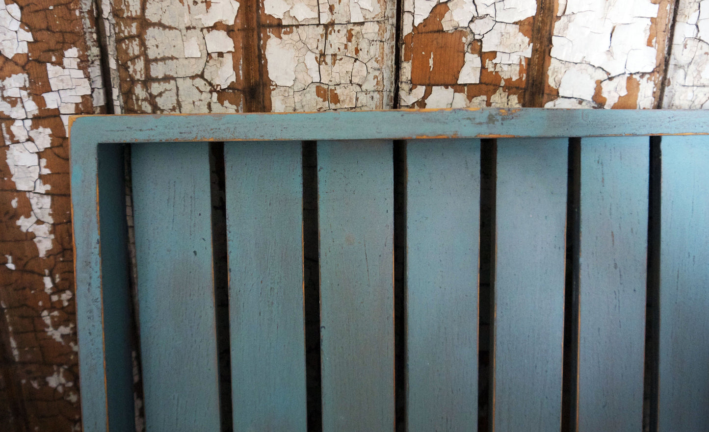 Vintage wooden slatted tray painted in layers of soft grey and blue