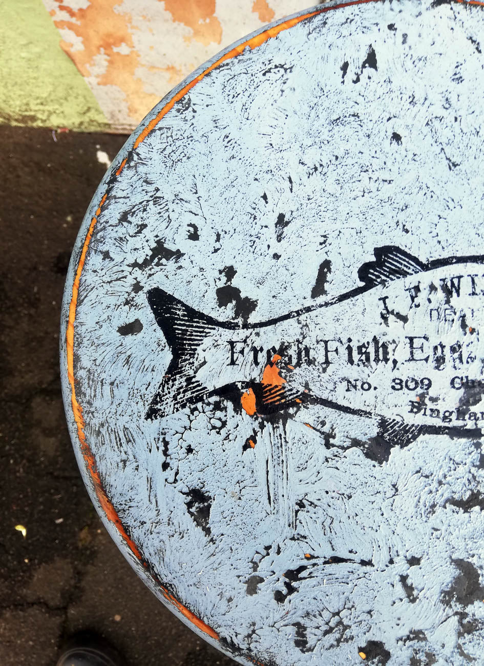 Vintage wooden stool with retro fish design on the seat, painted using saltwash