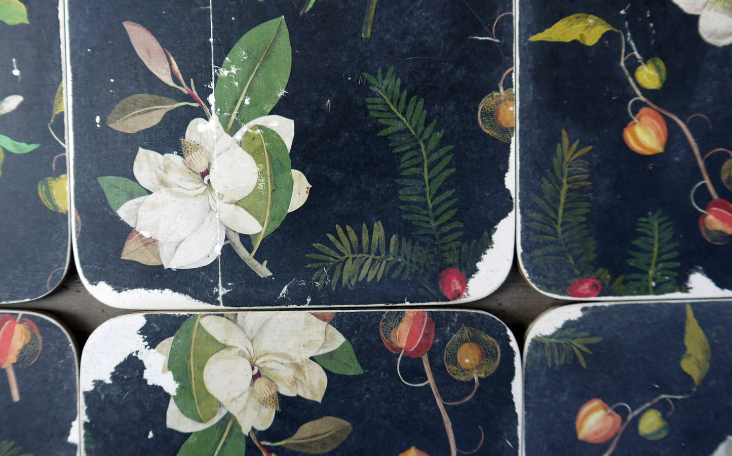 Set of six vintage paper coasters in dark grey and floral design on white.
