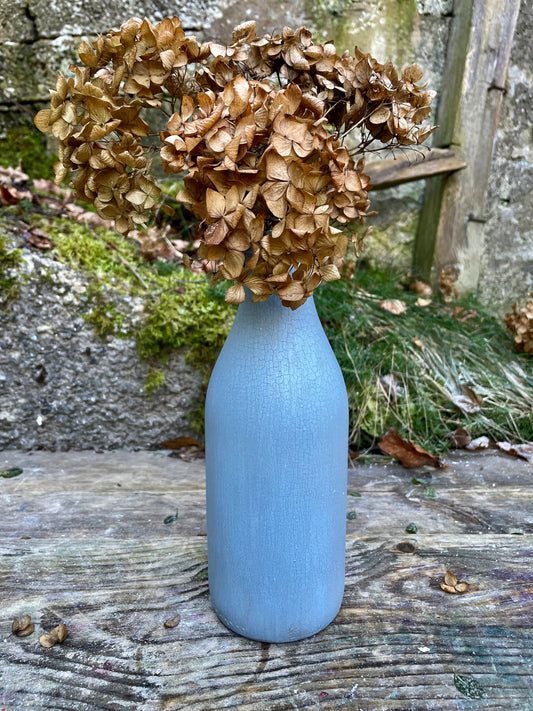 Bottle bud vase painted in layers of textured crackled blue milk paint