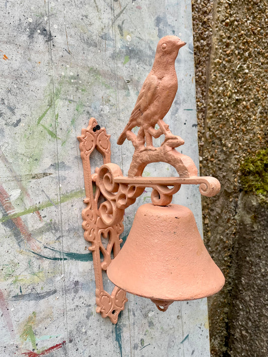 Retro painted metal bird manual door bell in peachy pink