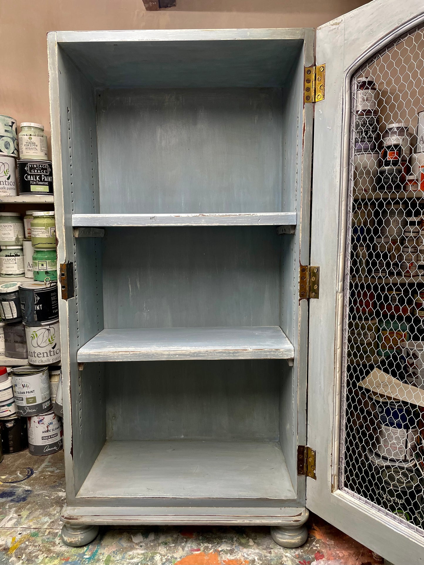 Vintage chicken wire cabinet painted in layers of traditional milk paint