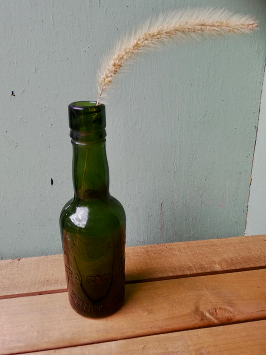 Vintage green glass bottle bud vase with dried seed head