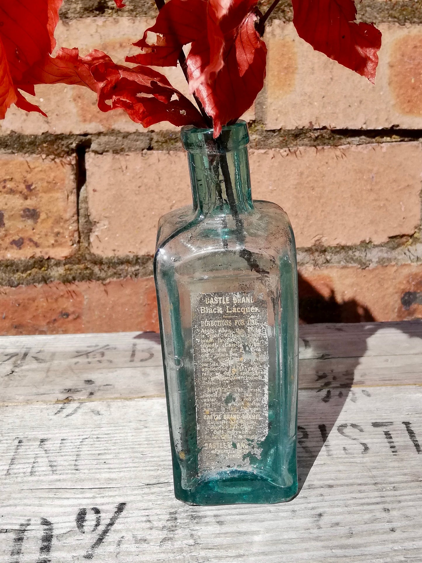 Vintage blue  glass bottle bud vase with dried leaves