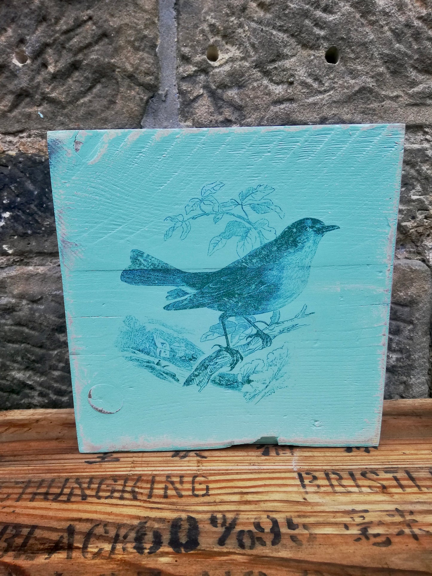 Painted wooden art block with bird design.
