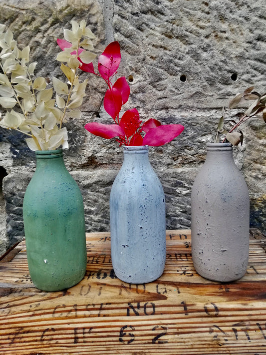 Bottle bud vase painted in layers of textured chalk paint comes with dried flower stems.