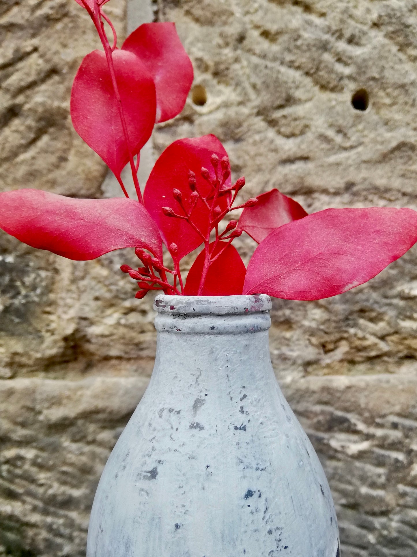 Bottle bud vase painted in layers of textured chalk paint comes with dried flower stems.