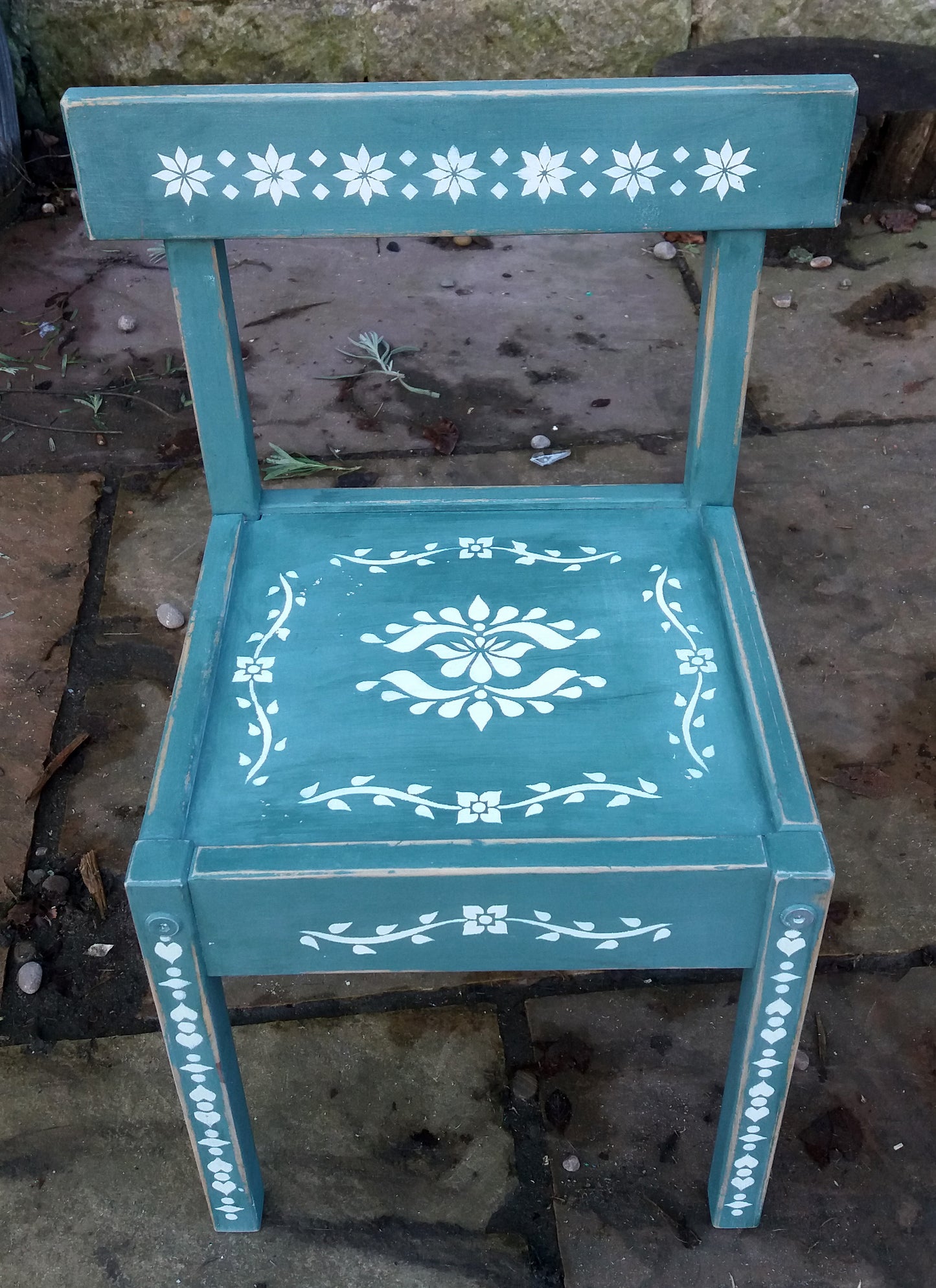 Little Children's chair painted in a deep green with folk art stencil design in white