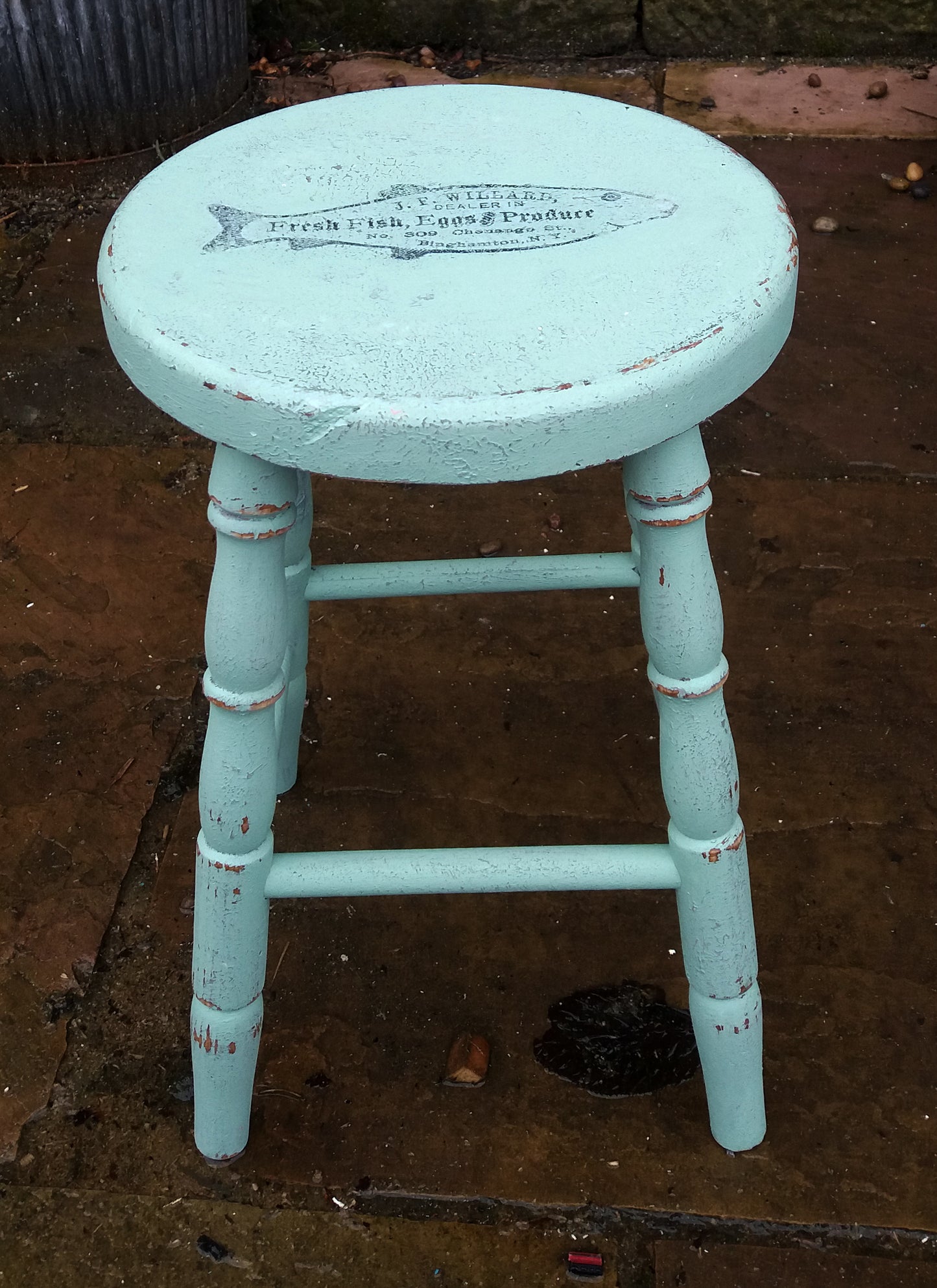 Vintage wooden stool painted in layers of textured paint with fish motif