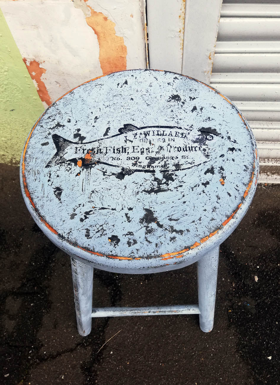 Vintage wooden stool with retro fish design on the seat, painted using  saltwash