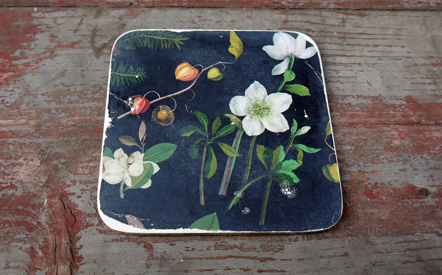 Set of six vintage paper coasters in dark grey and floral design on white.
