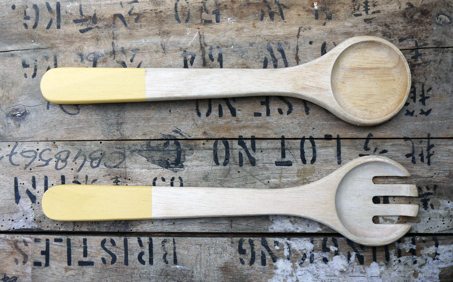 Set of vintage wooden salad servers with yellow handles.